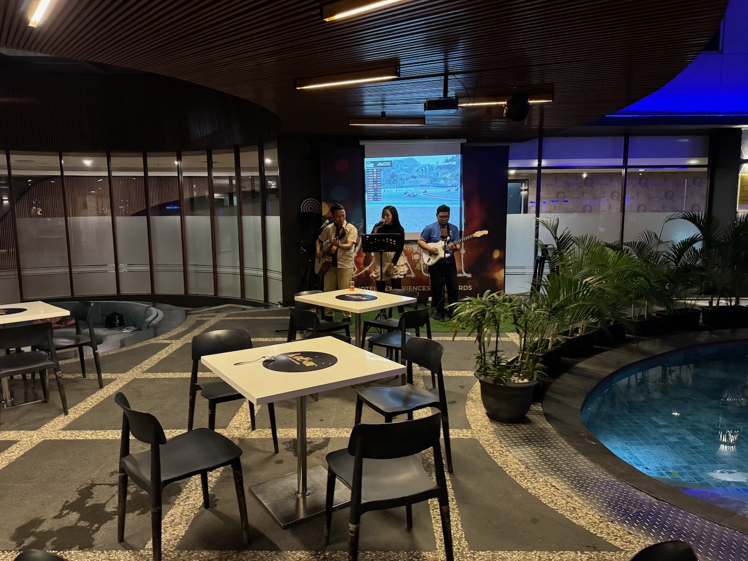 a group of people playing instruments in a room with a pool