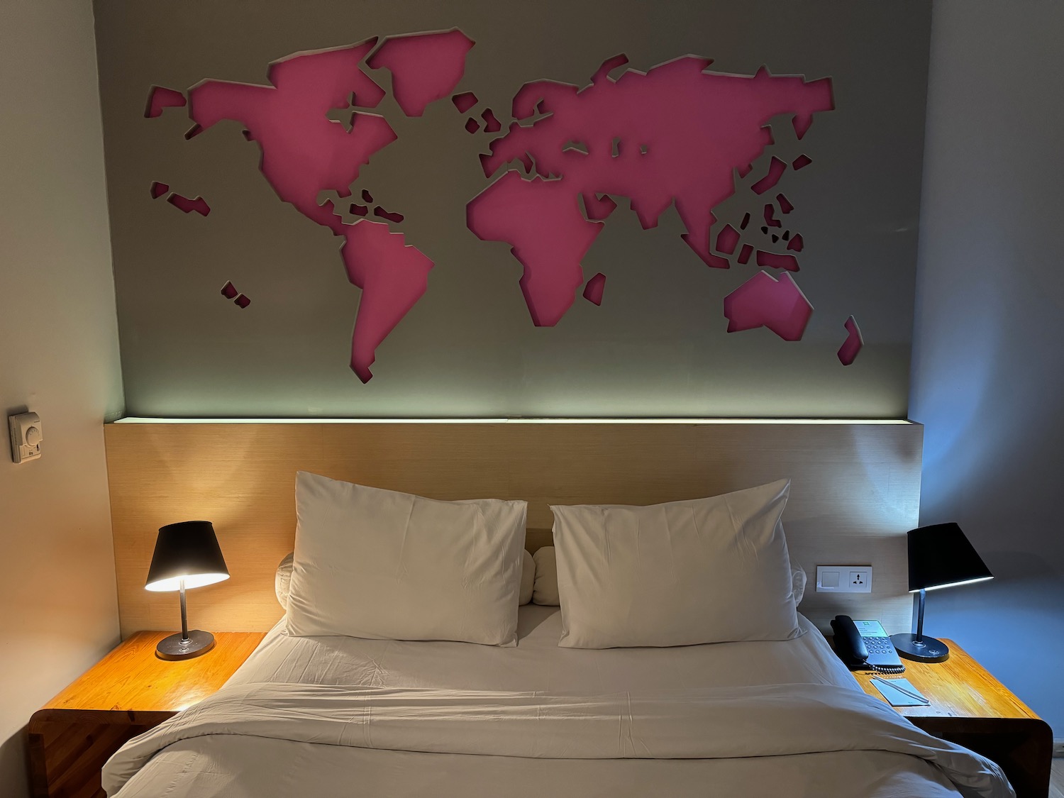 a bed with a map of the world on the wall