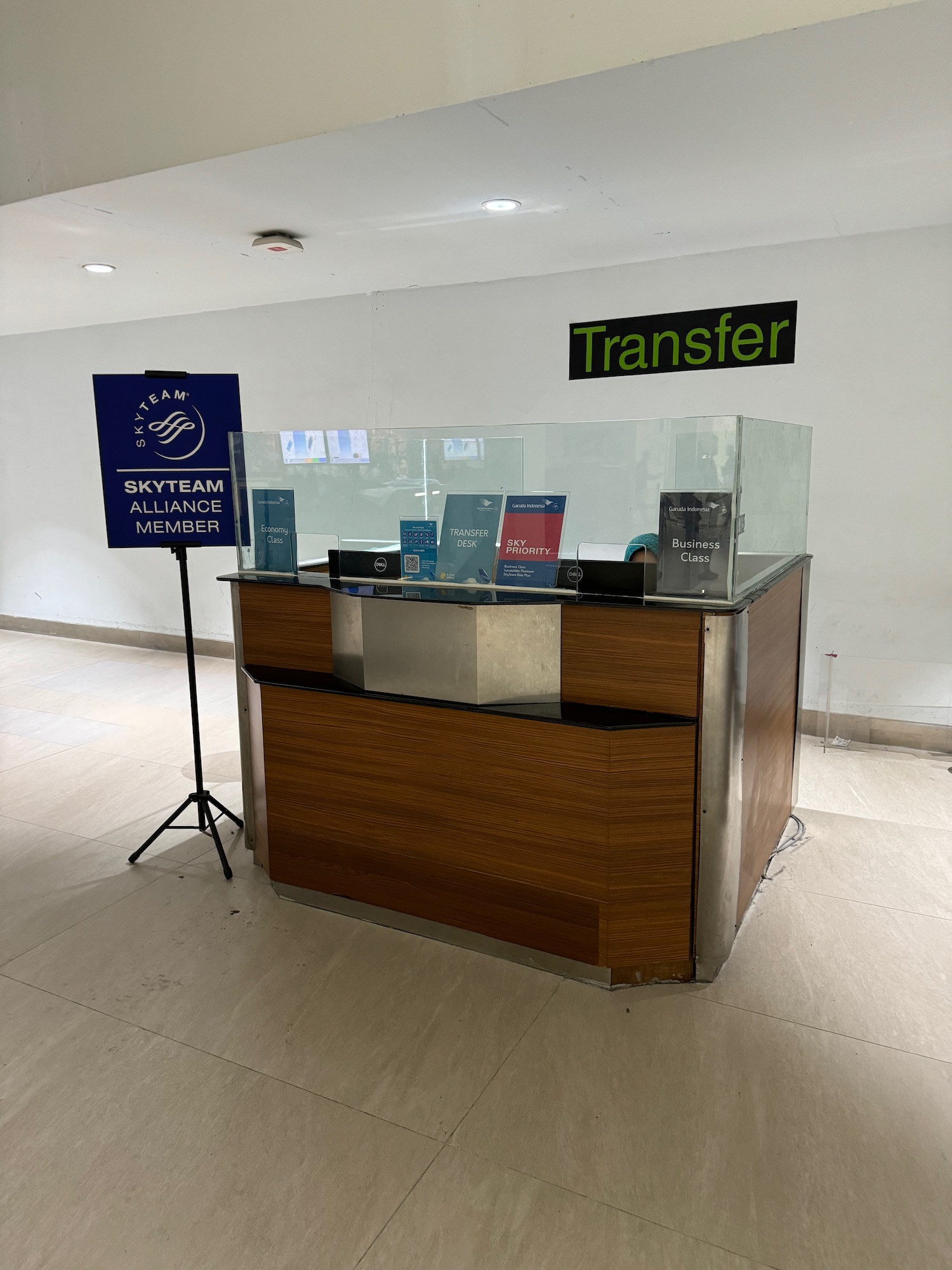 a glass front desk with a sign and a stand