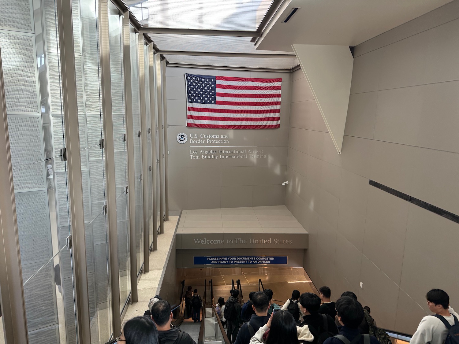 a group of people walking up stairs in a building with a flag from the ceiling