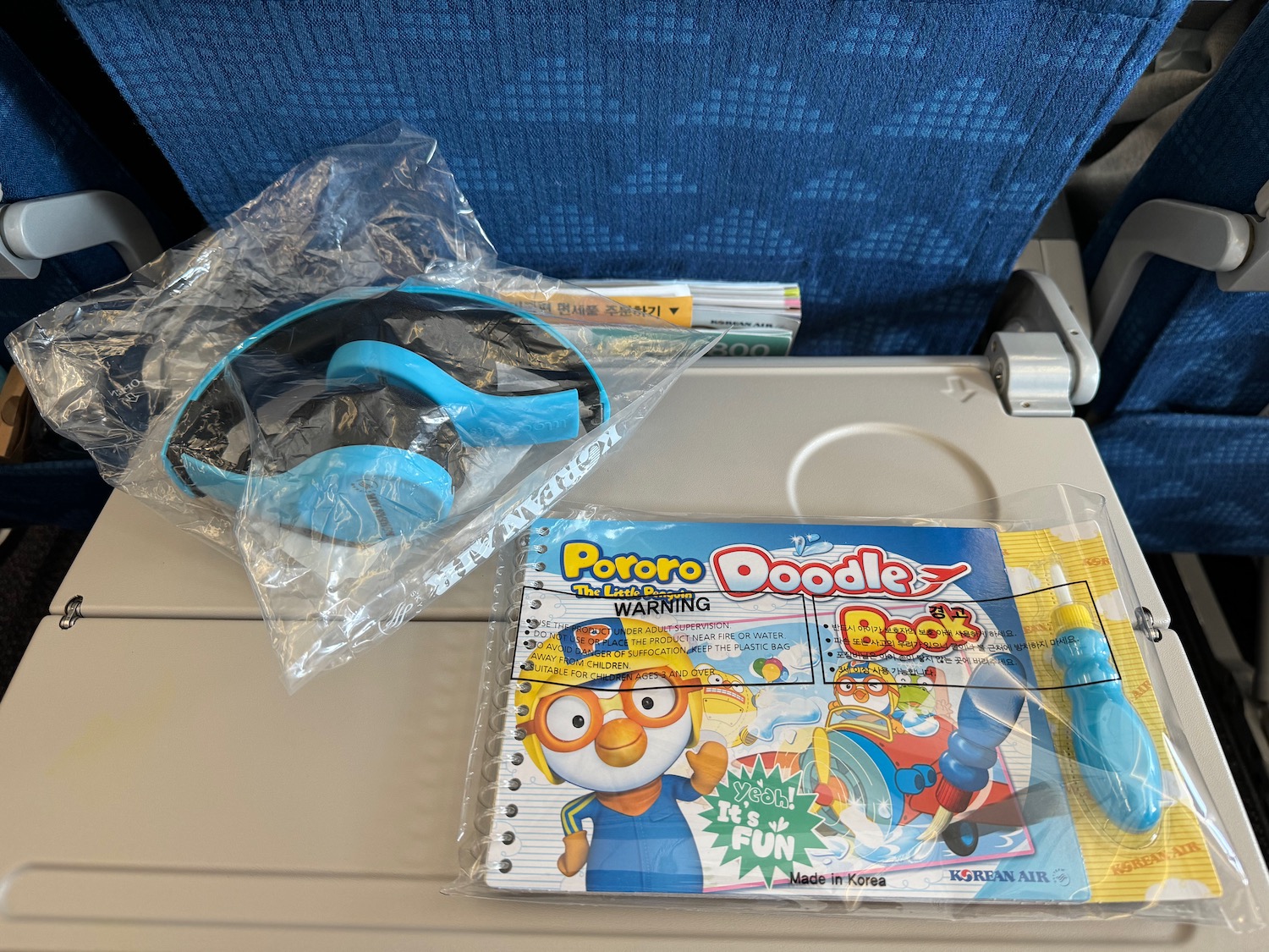 a blue glasses and a notebook on a plane