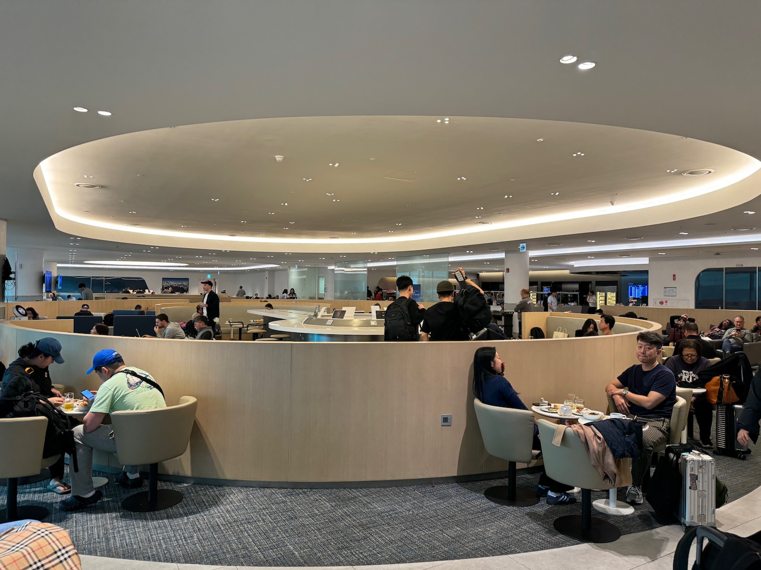 people sitting at tables in a room with a circular ceiling