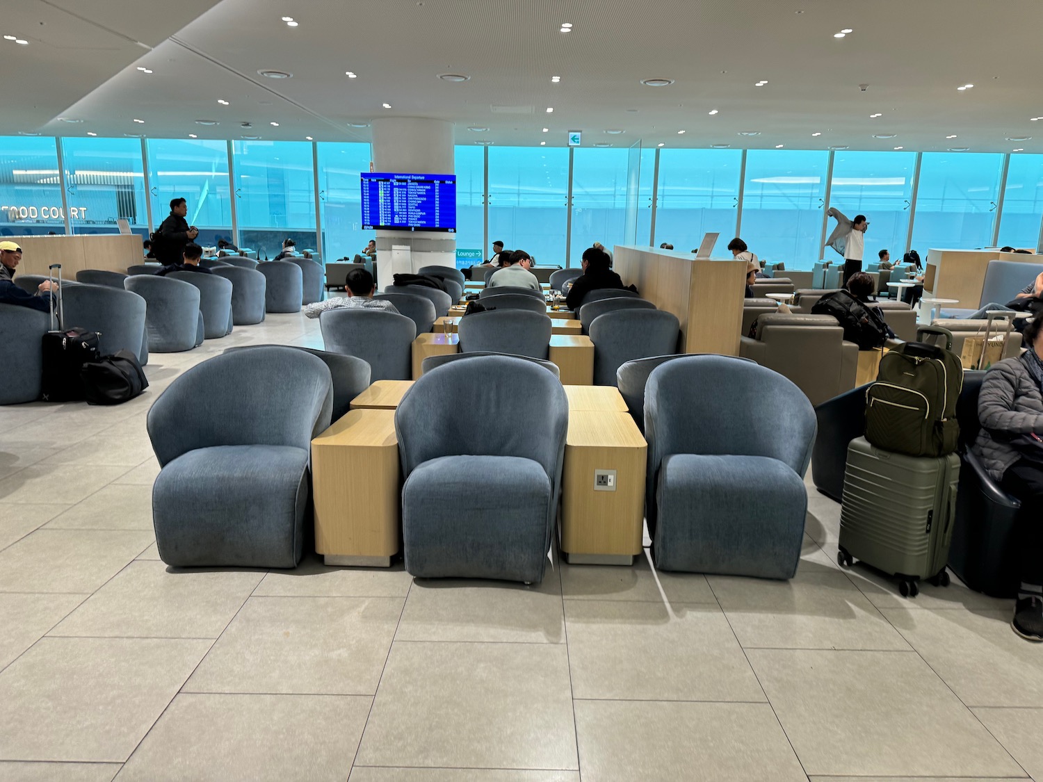 a group of people sitting in chairs in a room with windows