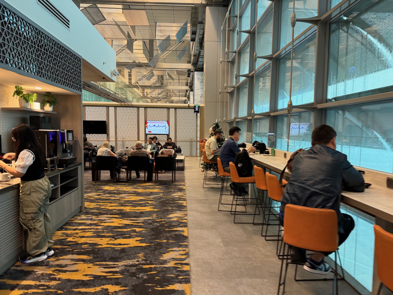 a group of people sitting in chairs in a room with windows