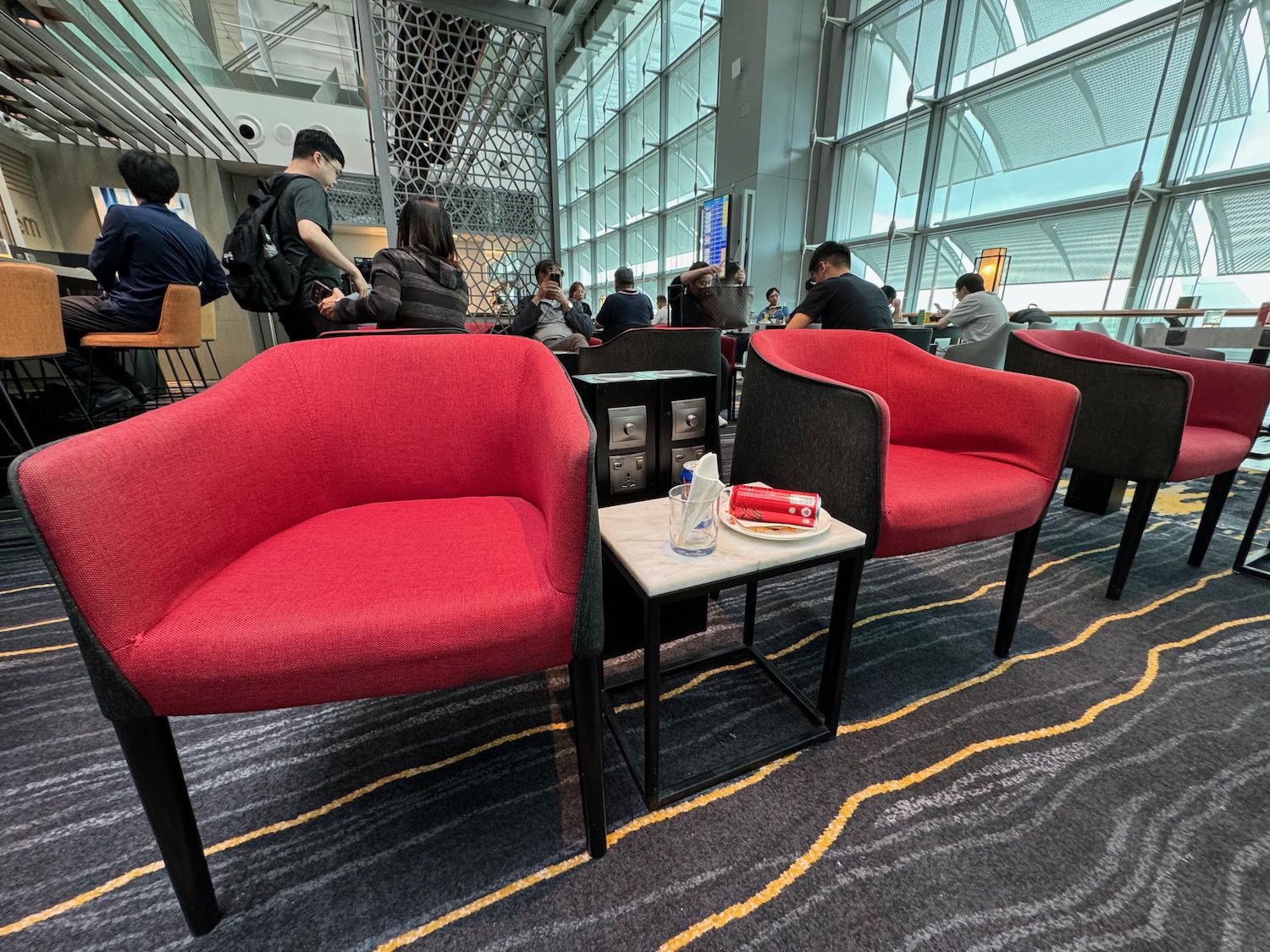 a group of people sitting in a room with red chairs