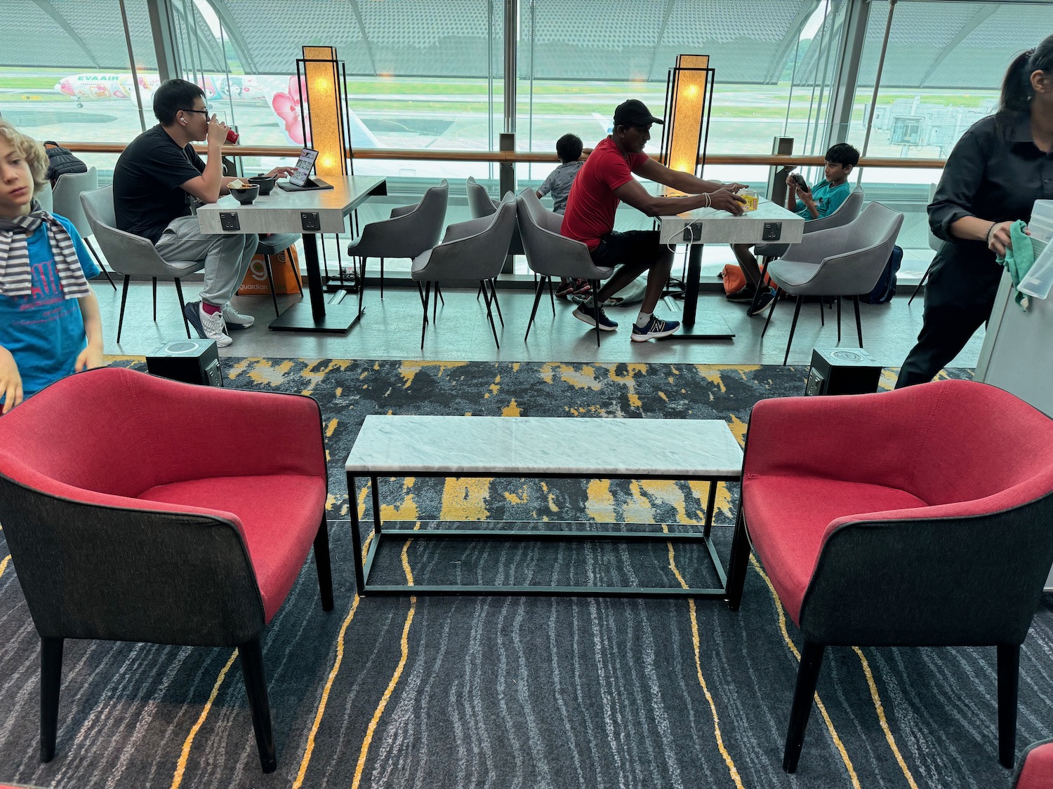 people sitting at tables in a room with chairs and tables