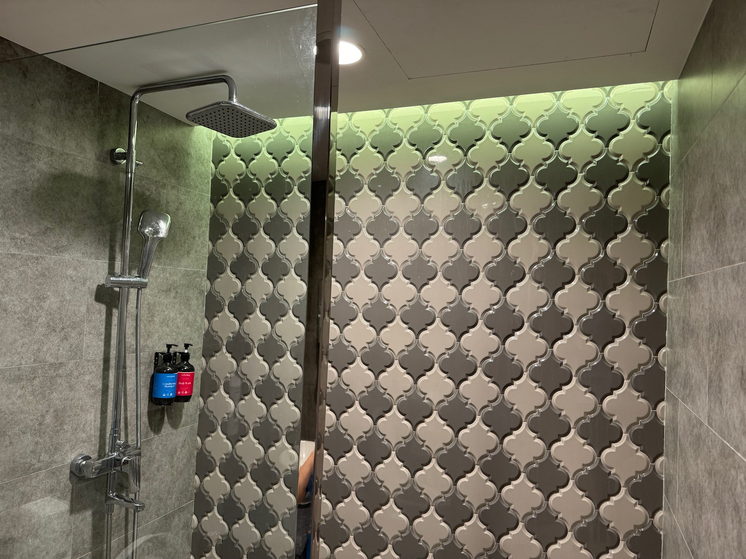 a shower with a tile wall