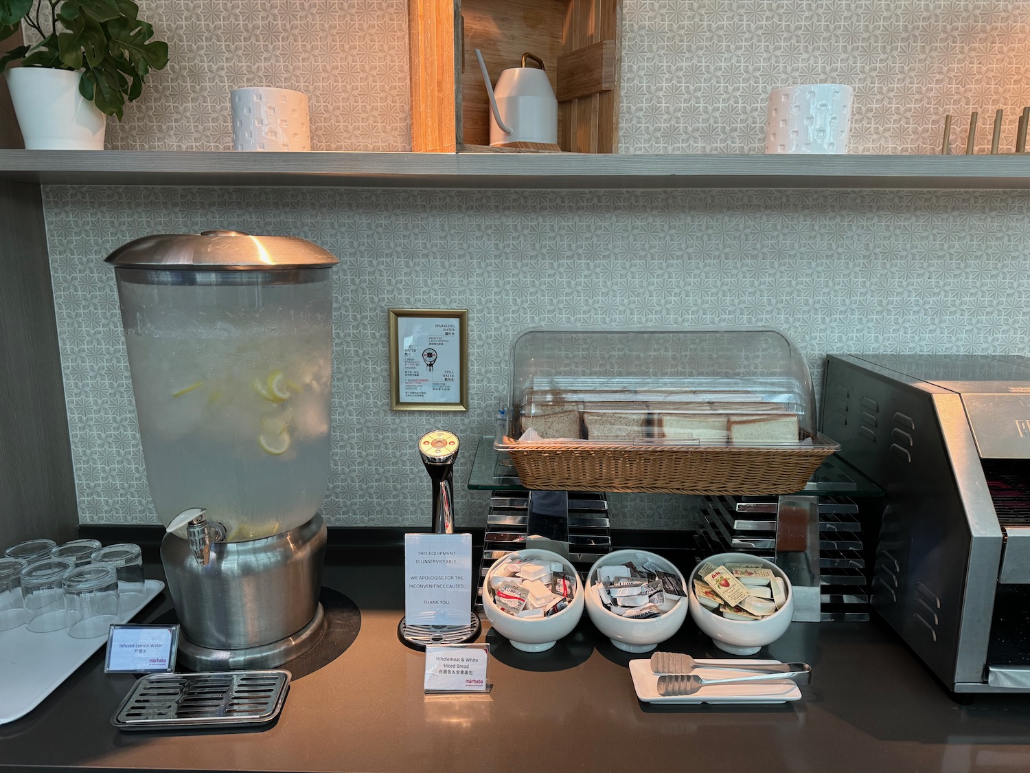 a counter with a container of food and a drink dispenser