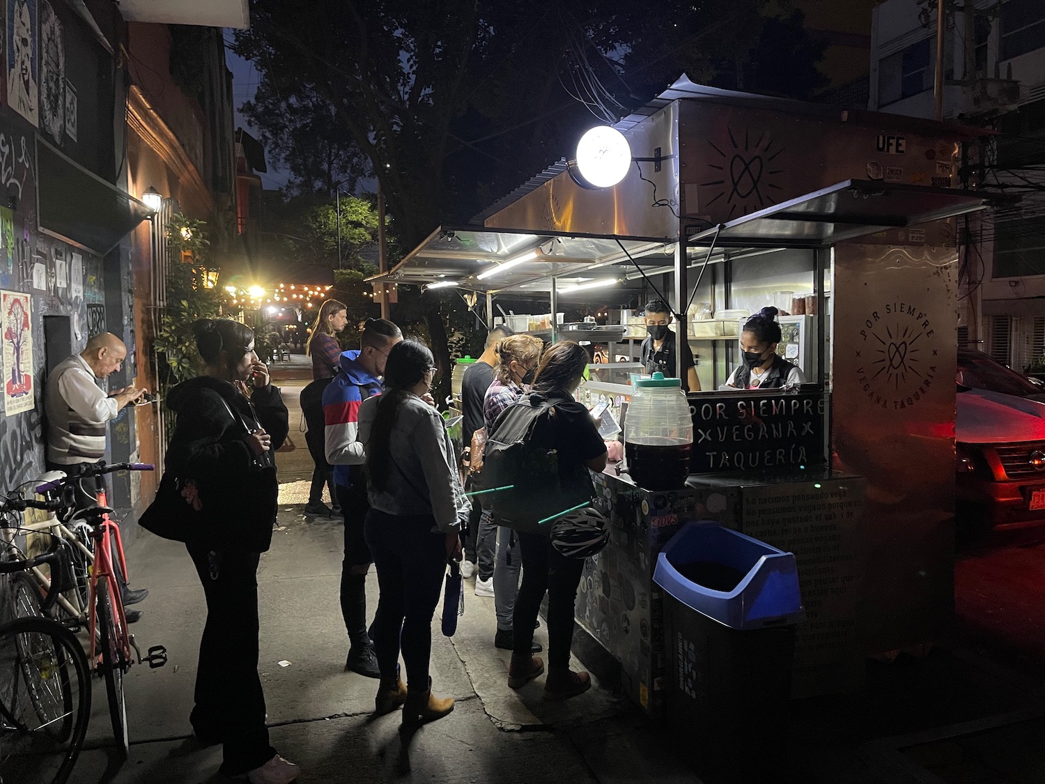 a group of people standing outside a food truck