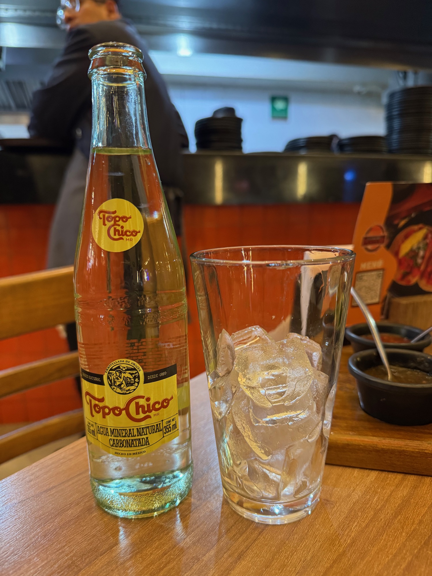 a bottle of liquid next to a glass of ice