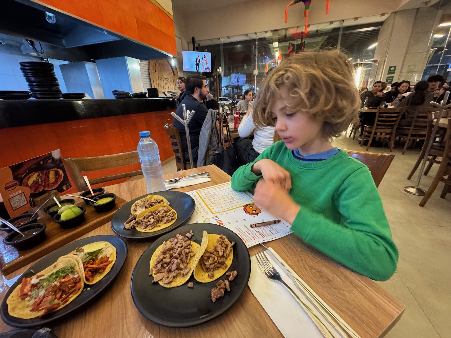 a child sitting at a table with food on plates