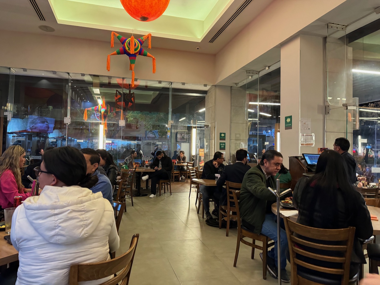 a group of people sitting at tables in a restaurant