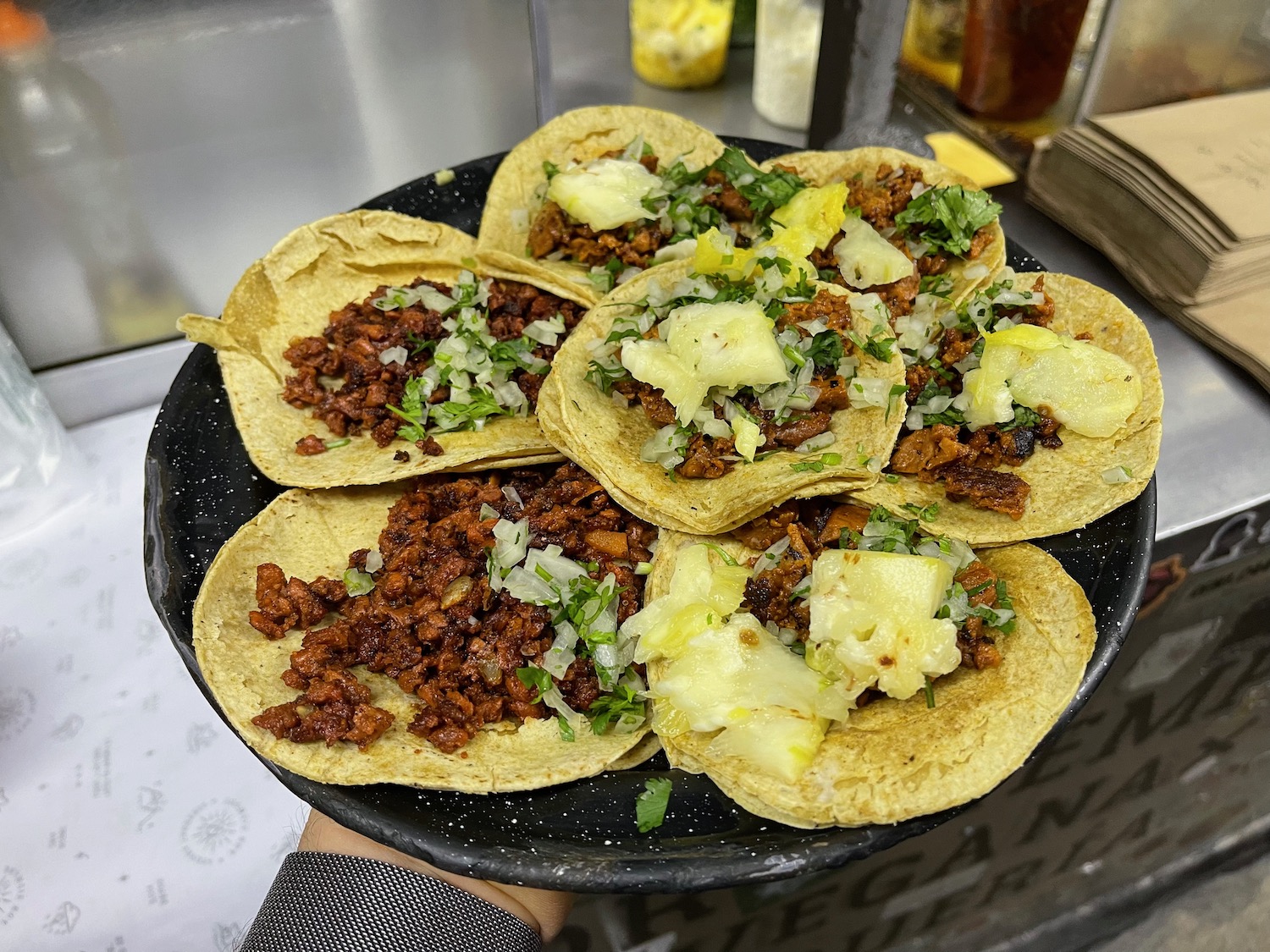 a plate of tacos with meat and pineapple