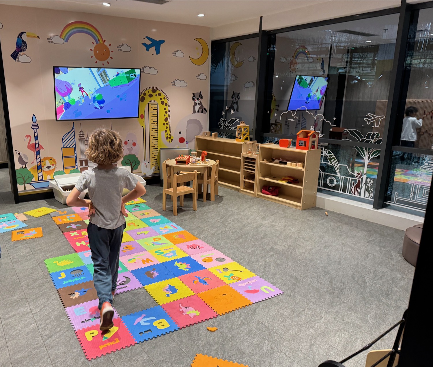 a child running on a rug in a room with a television