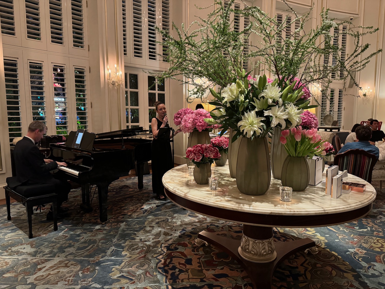 a group of flowers on a table in a room with a piano