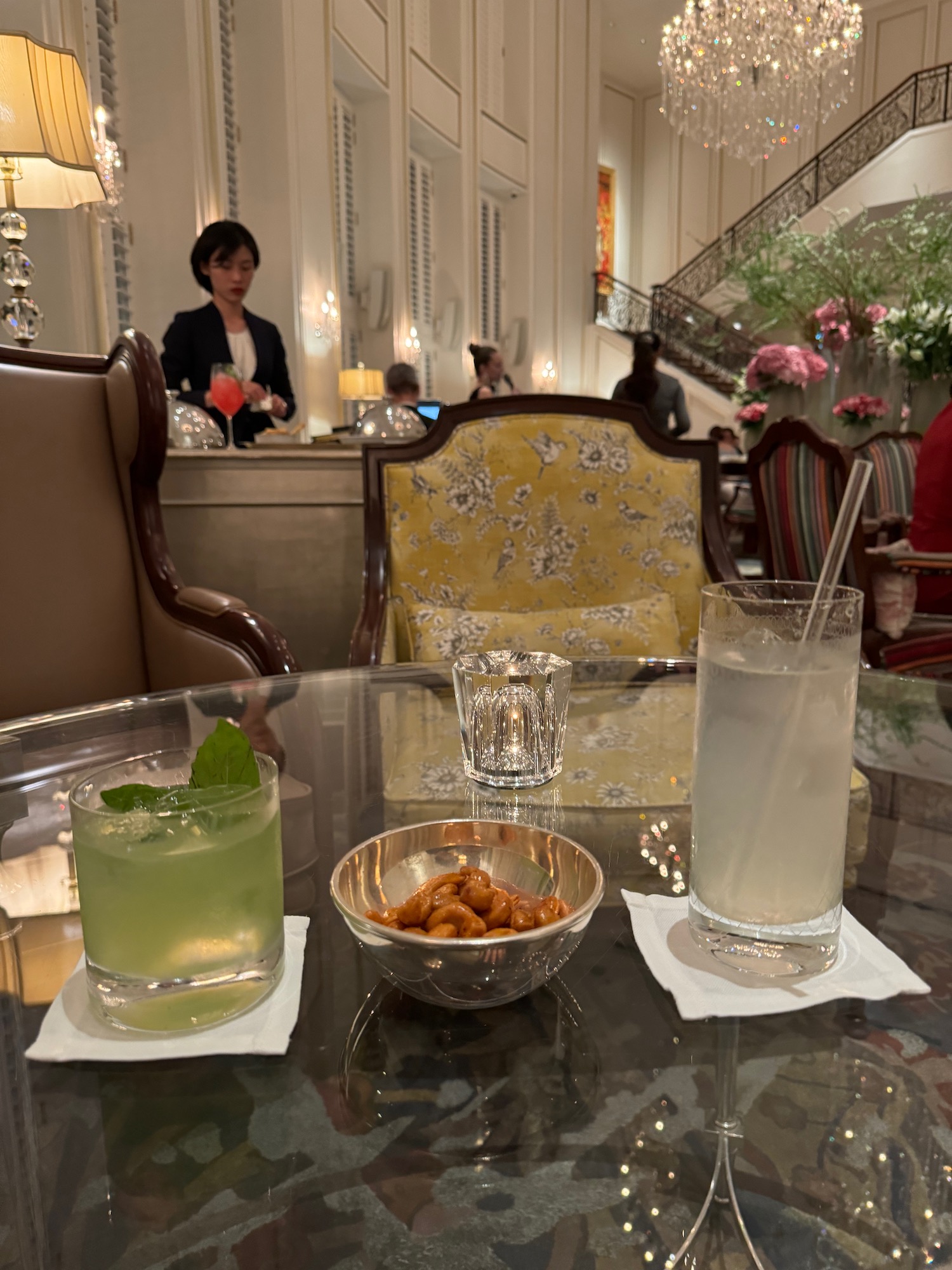 a glass table with drinks and a bowl of nuts