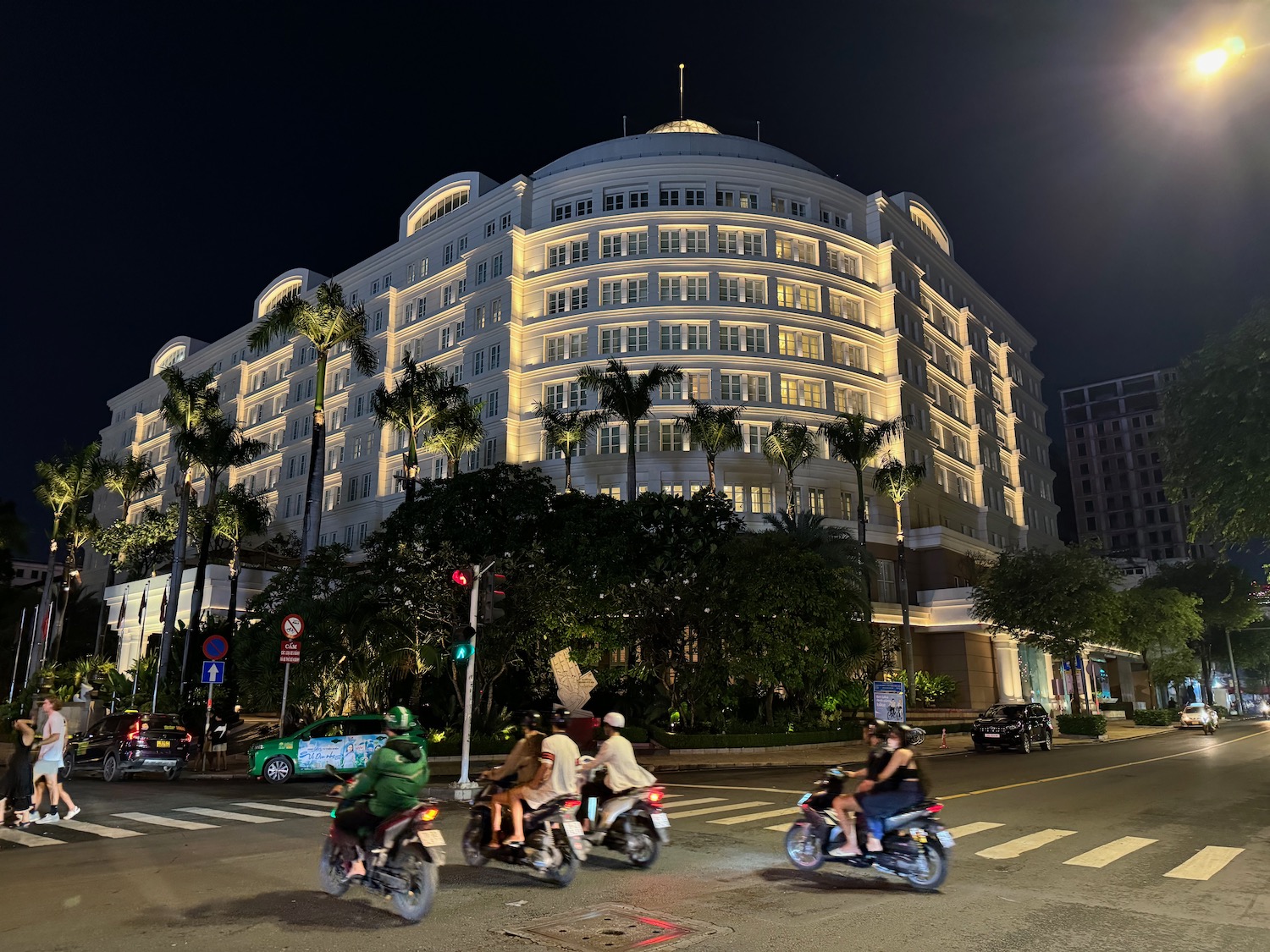 a group of people riding motorcycles in front of a large building