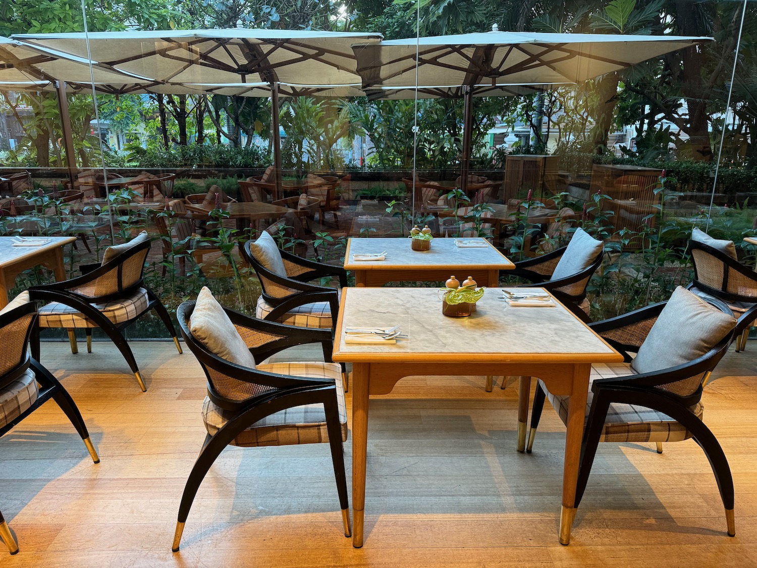 a table and chairs outside with trees in the background