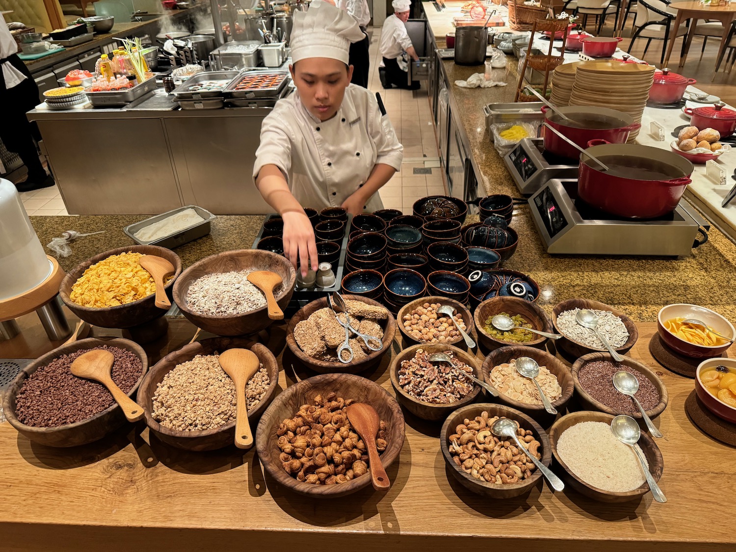 a chef in a kitchen with many bowls of food