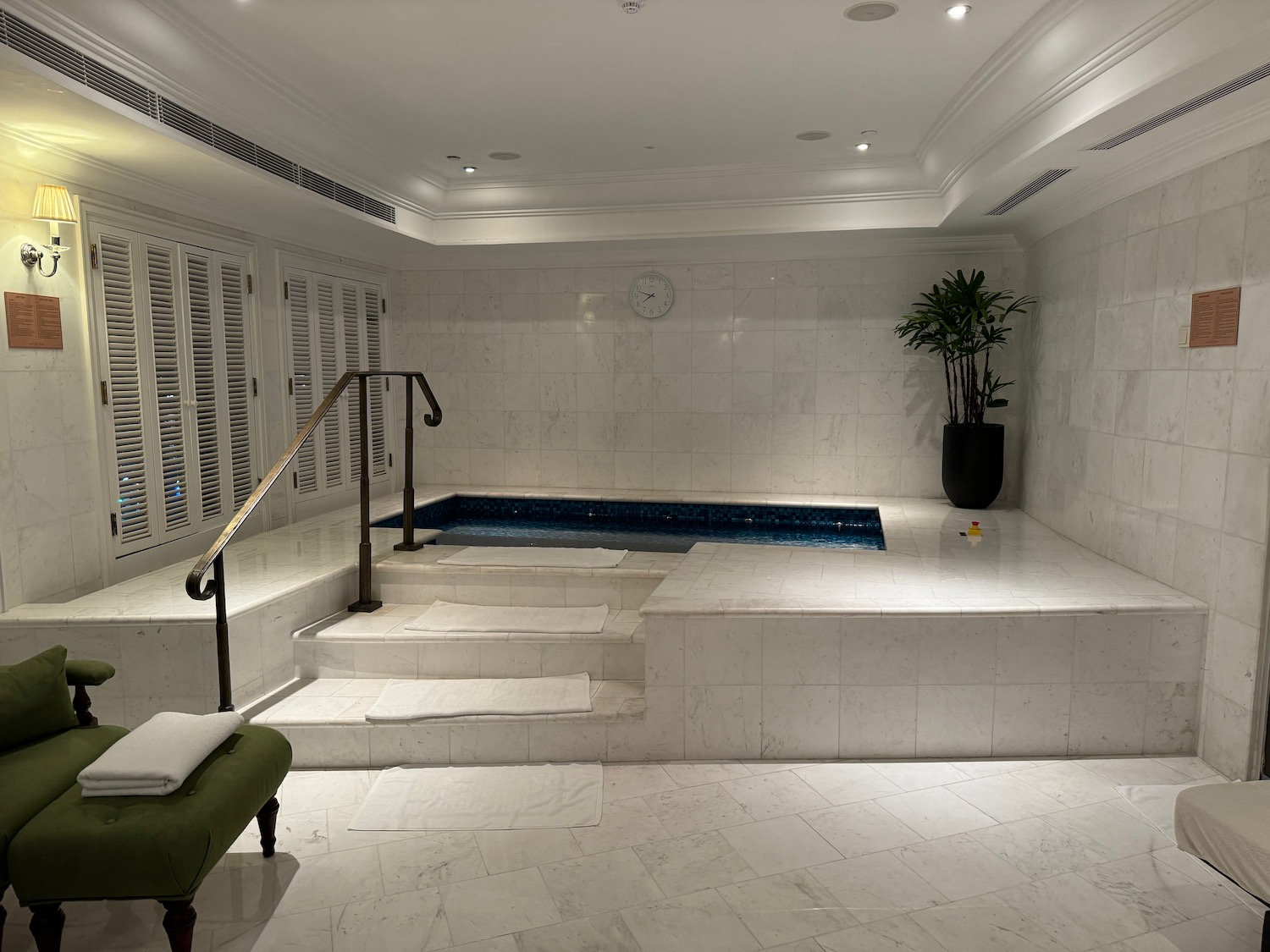 a indoor pool with stairs and a chair