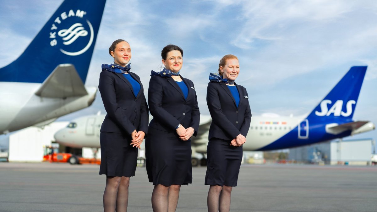 a group of women in uniform standing in front of an airplane