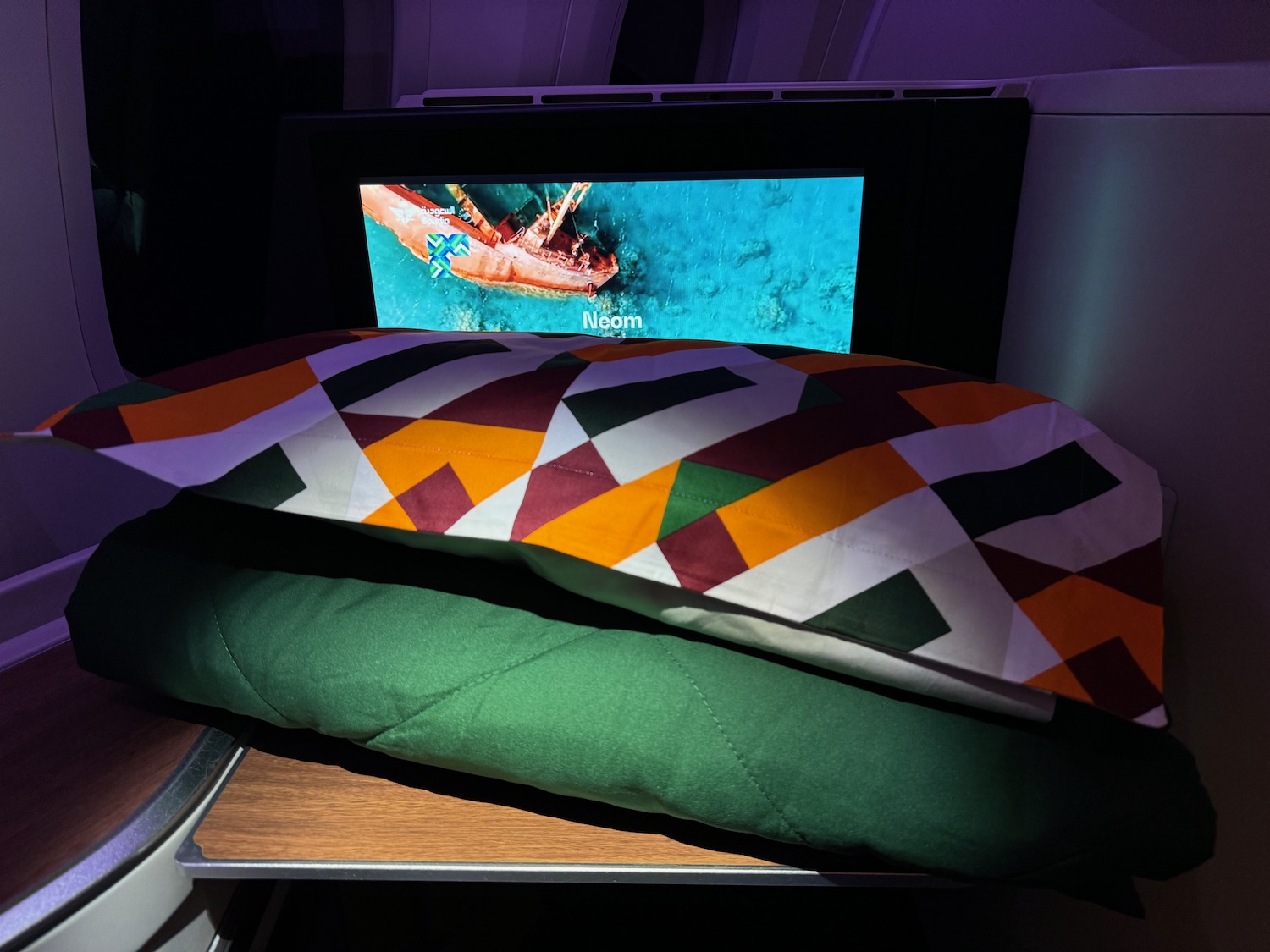 a bed with a blanket and a tv