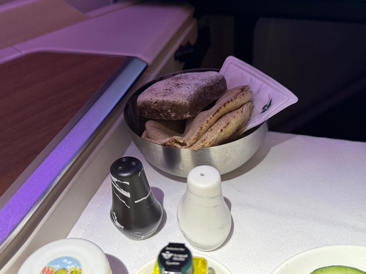 a bowl of bread and salt shakers on a table