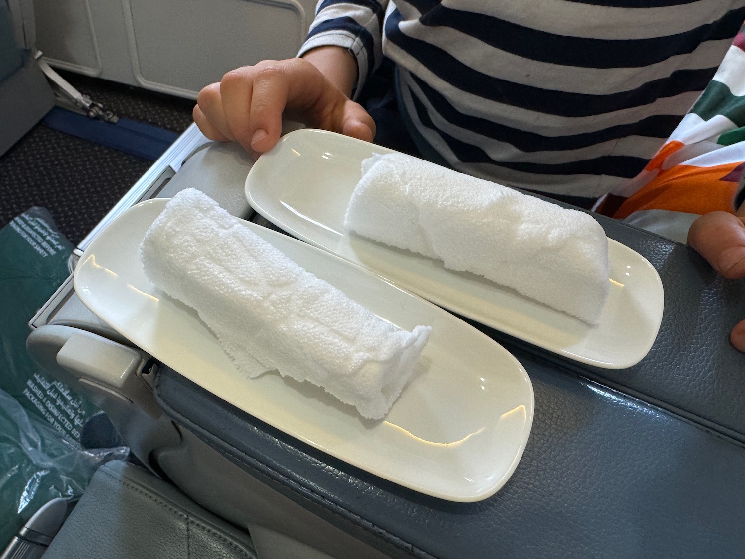 a person holding a plate with towels on it