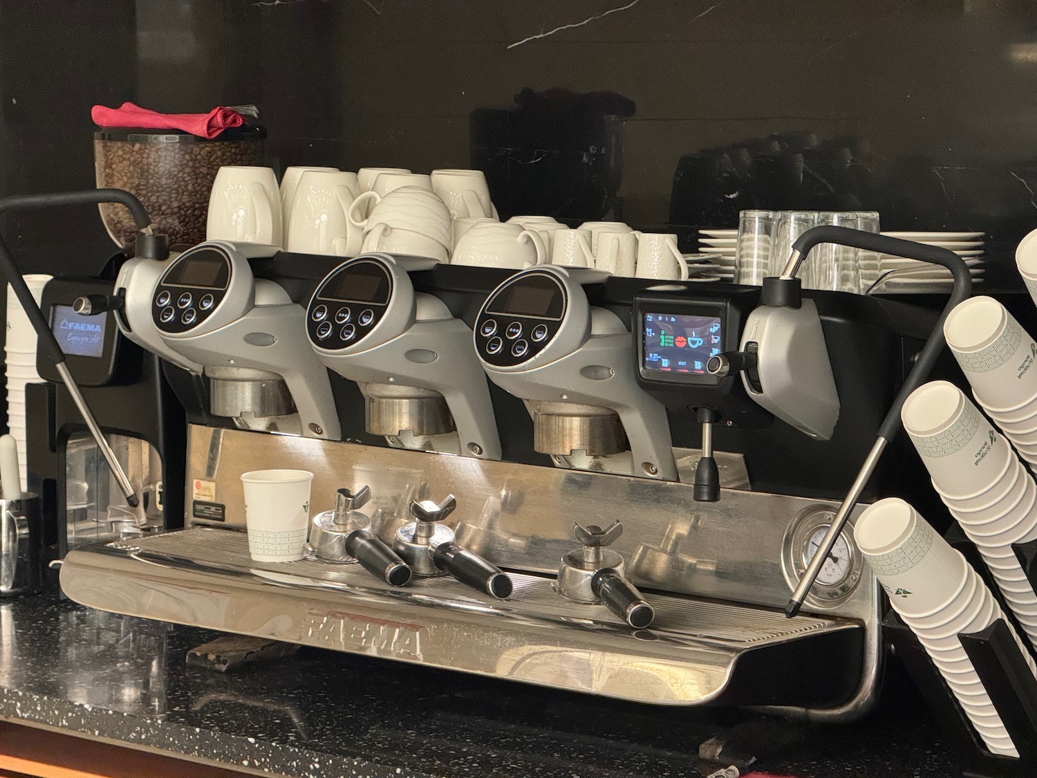 a coffee machine with several cups and a few other cups