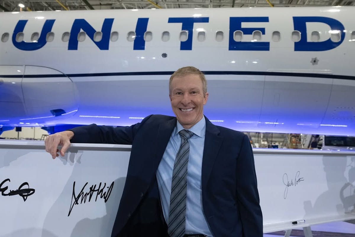 a man in a suit leaning on a plane