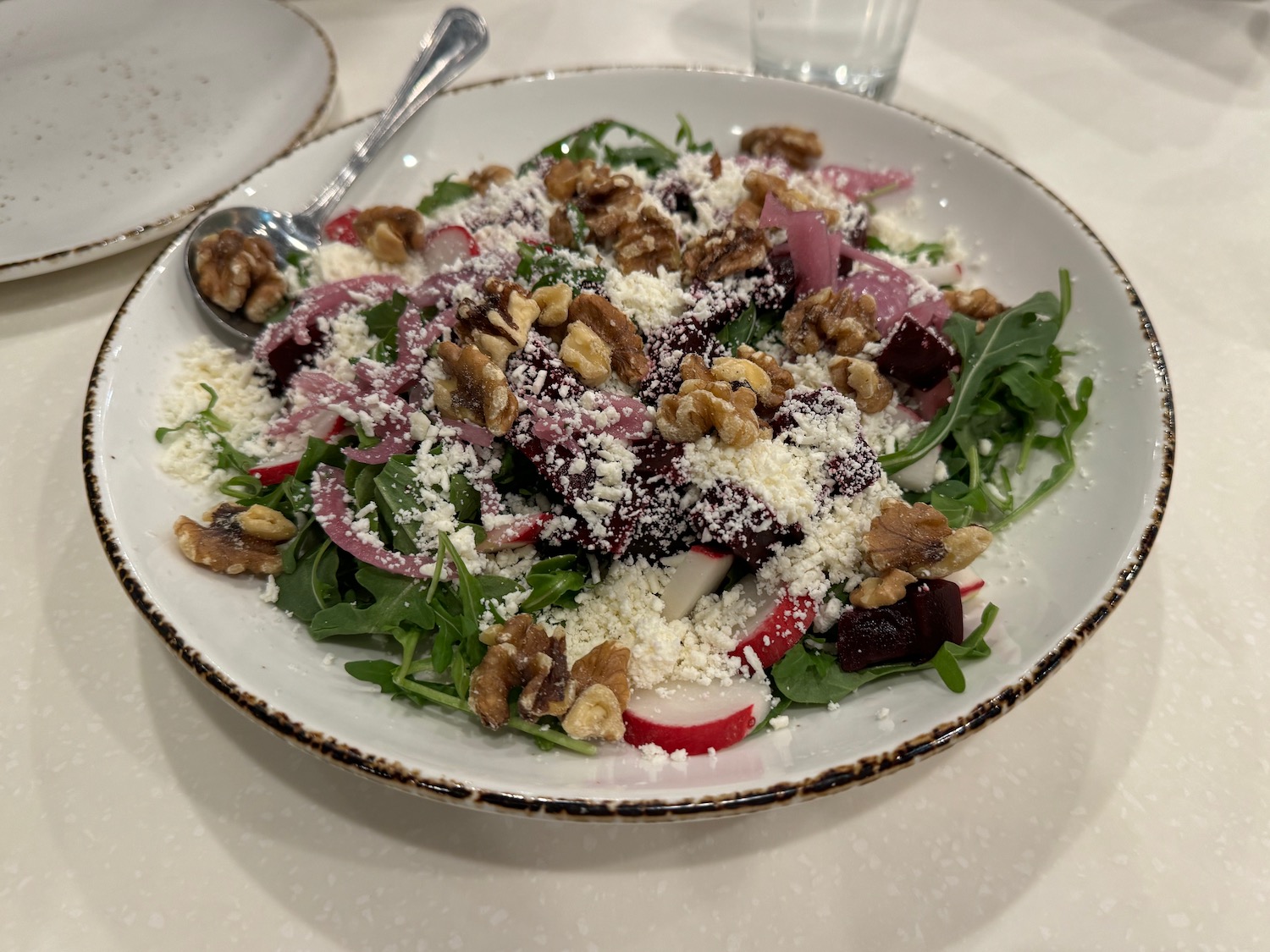 a salad with nuts and cheese on a plate