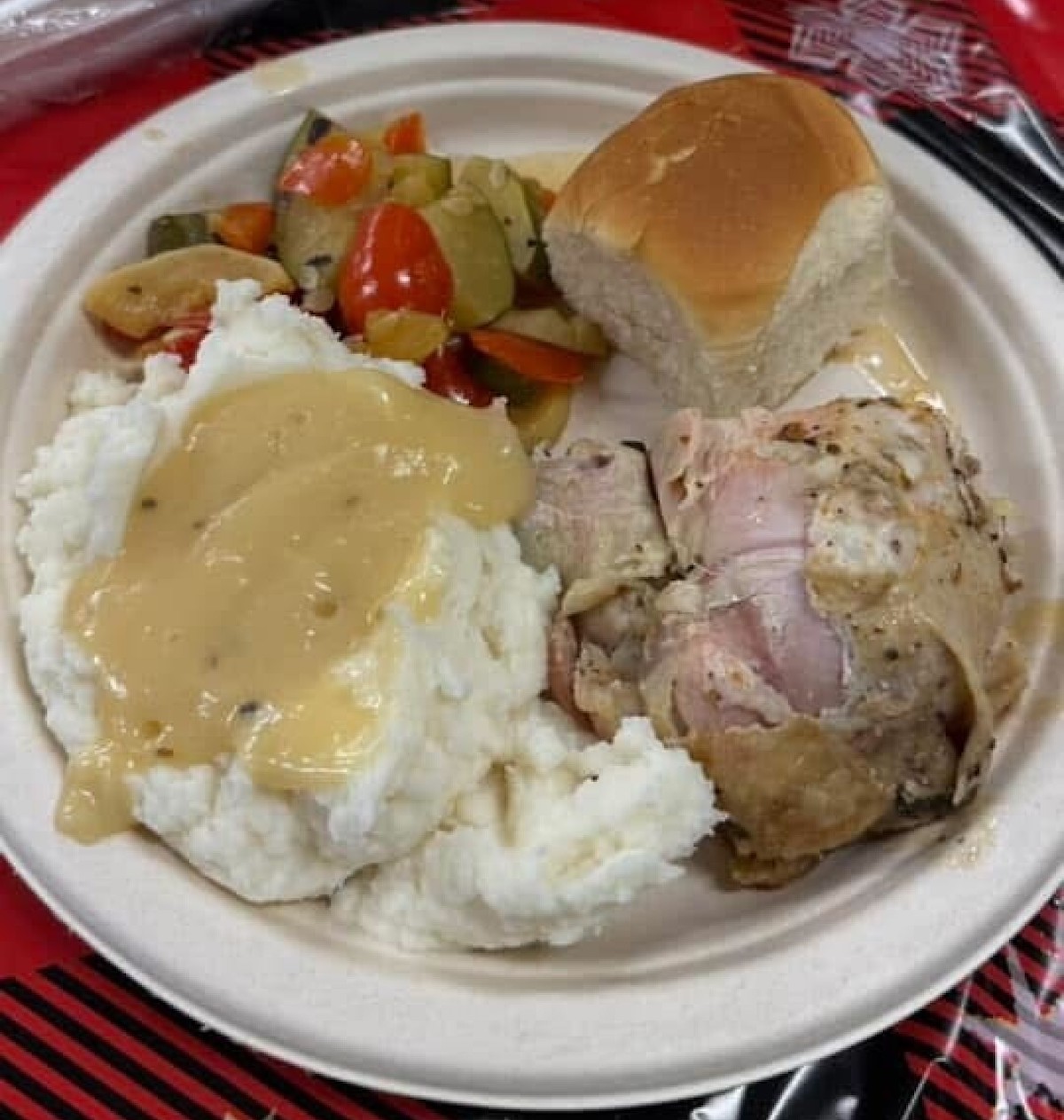 a plate of food on a red and white tablecloth