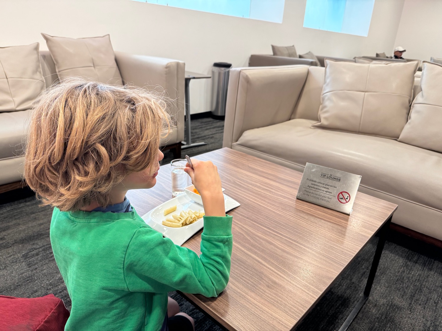 a child sitting at a table eating food