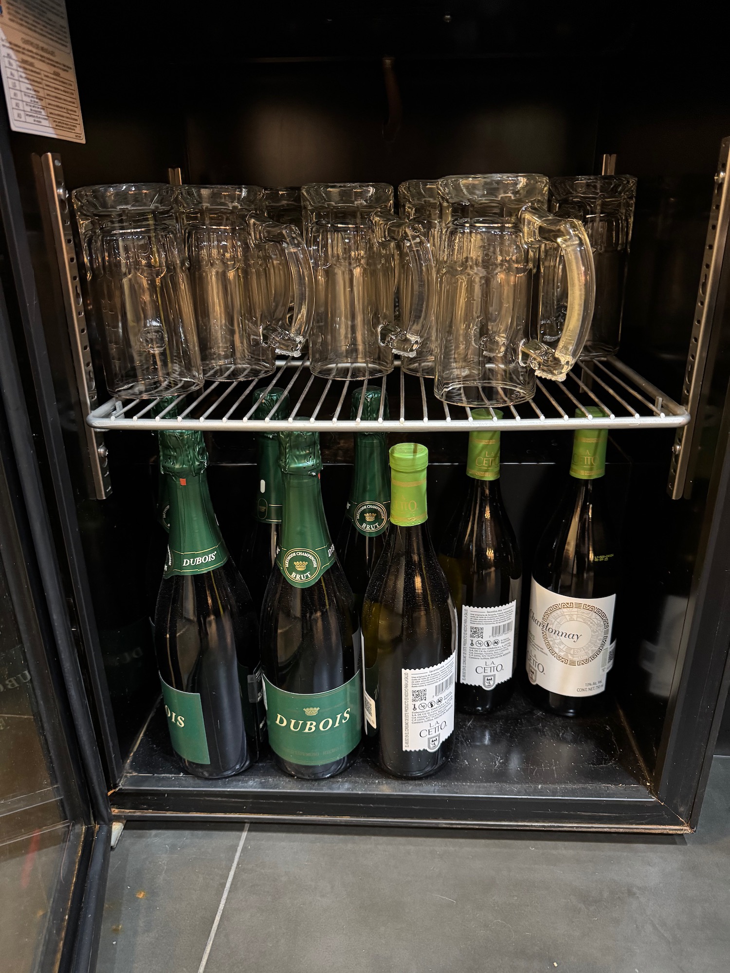 a shelf with wine glasses and bottles