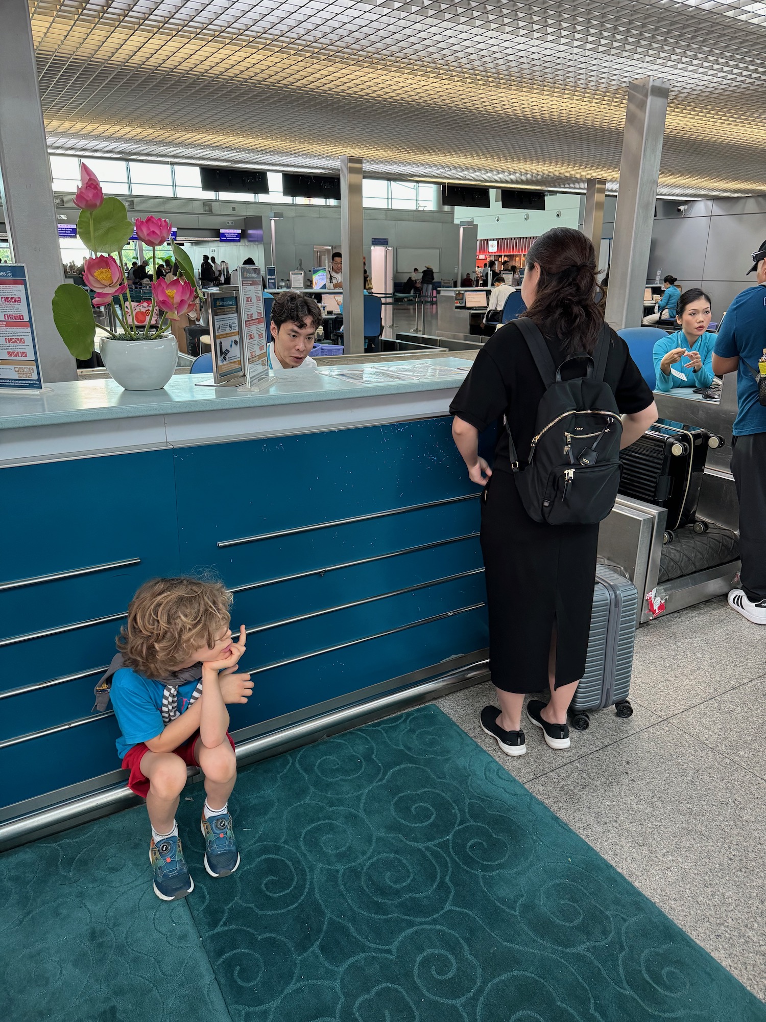 a woman standing next to a child sitting on a blue counter