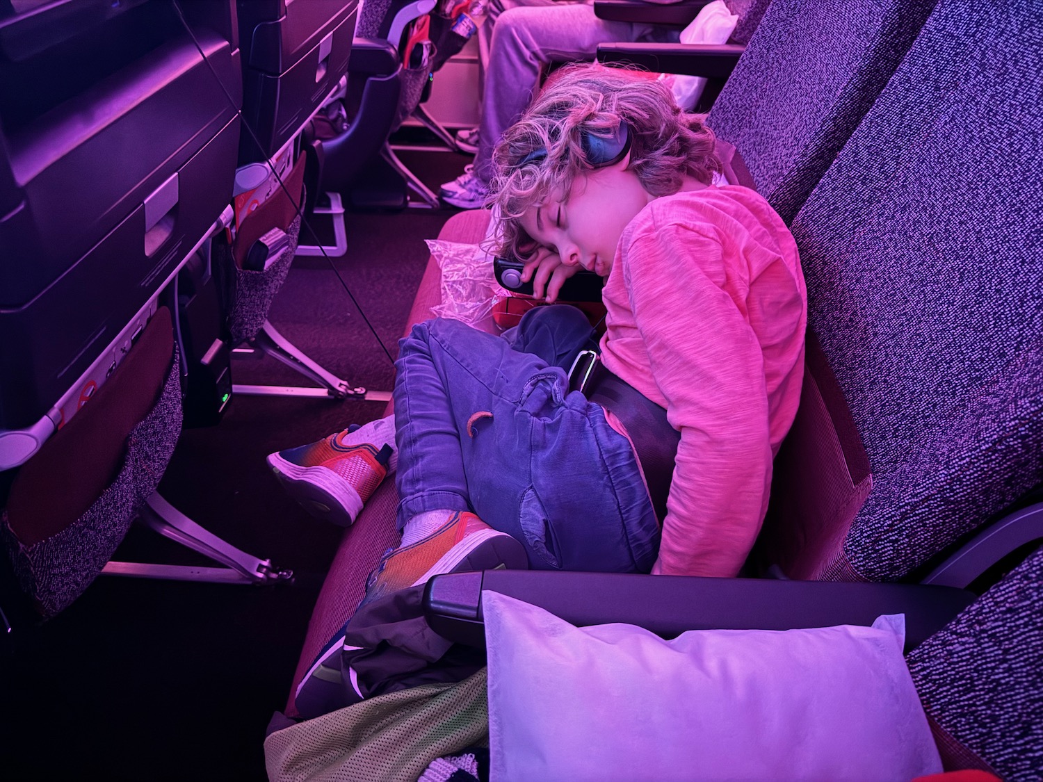 a child sleeping on an airplane seat