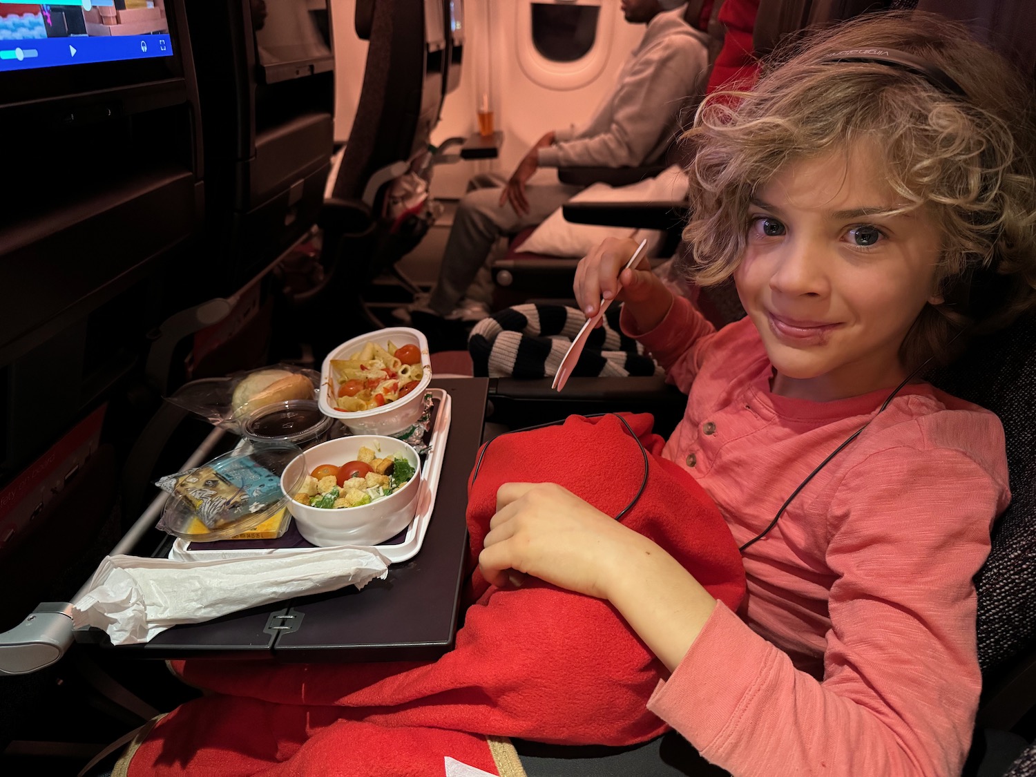 a girl eating food on an airplane