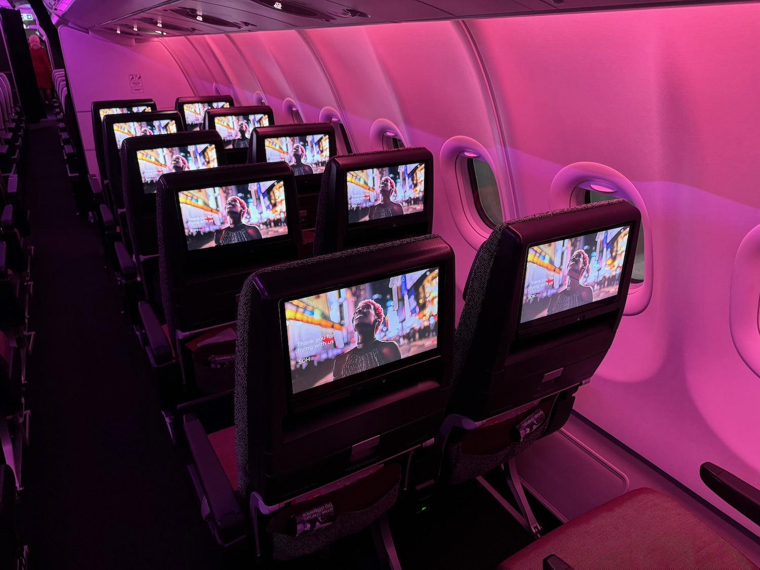 a row of seats with monitors on the side