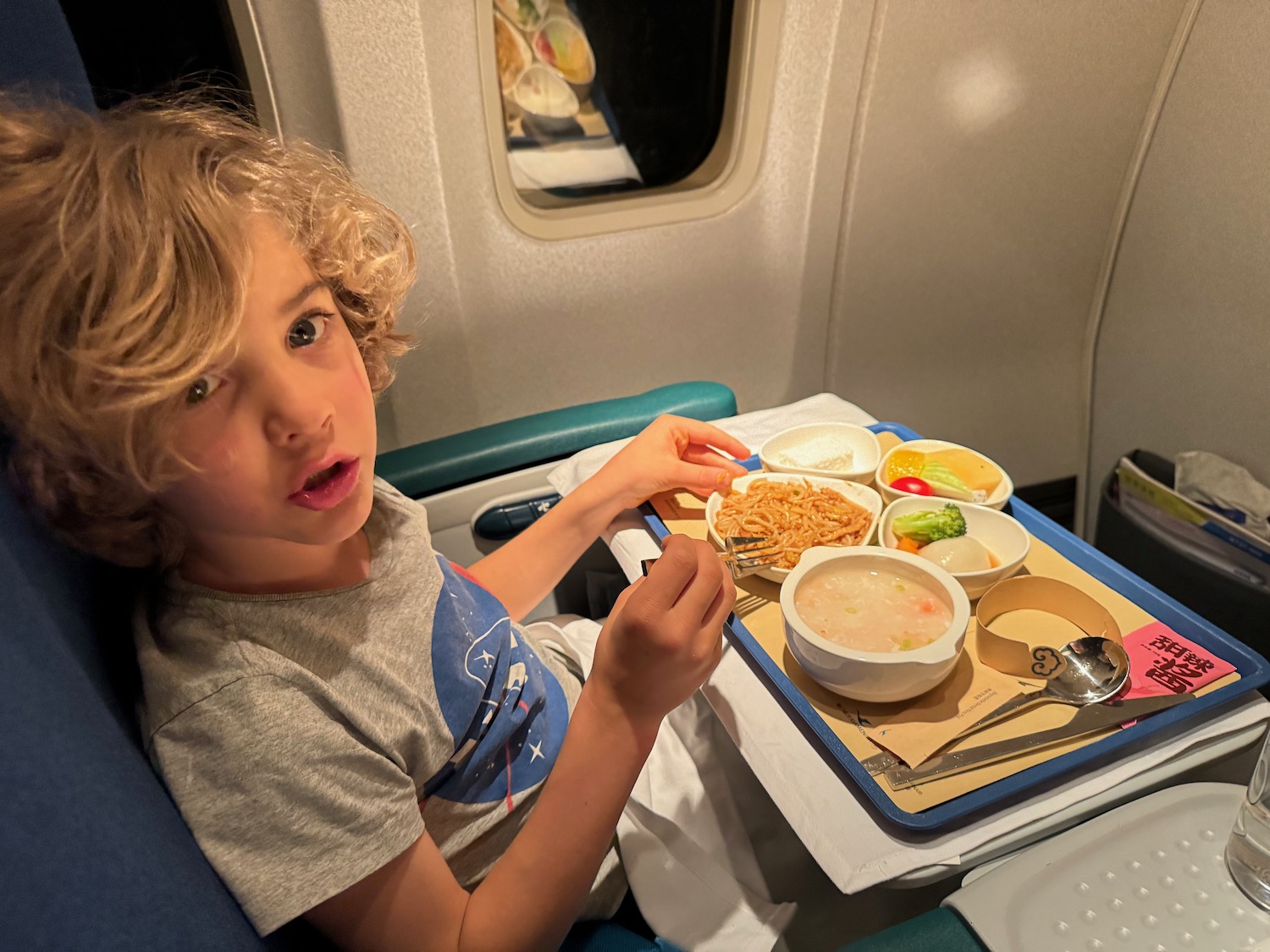 a boy eating food on a tray