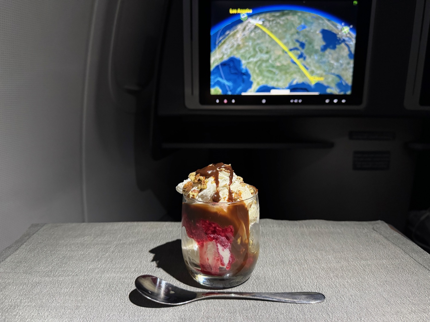 a dessert in a glass with a spoon in front of a television