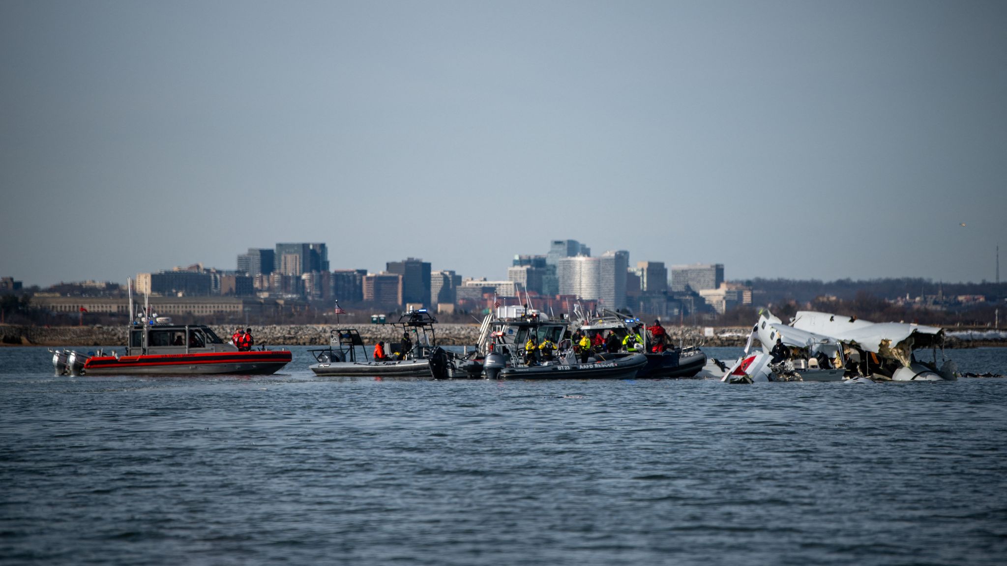 a group of people on boats in water with a plane in the background