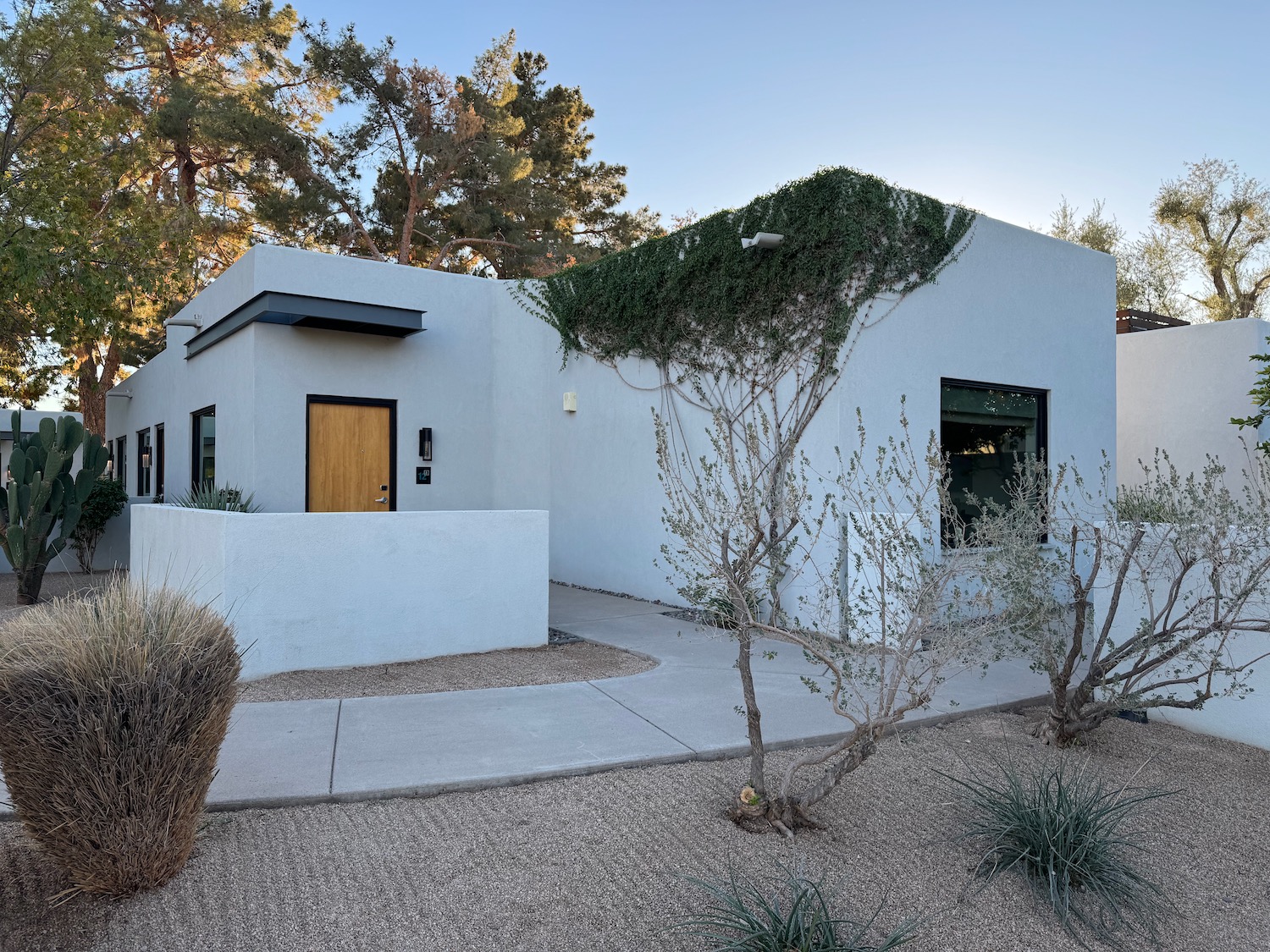 a white house with a green door and a concrete walkway