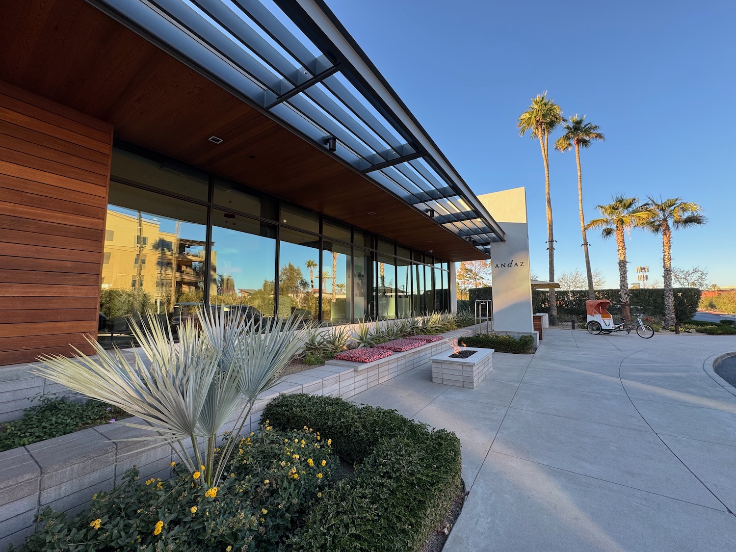 a building with a walkway and palm trees