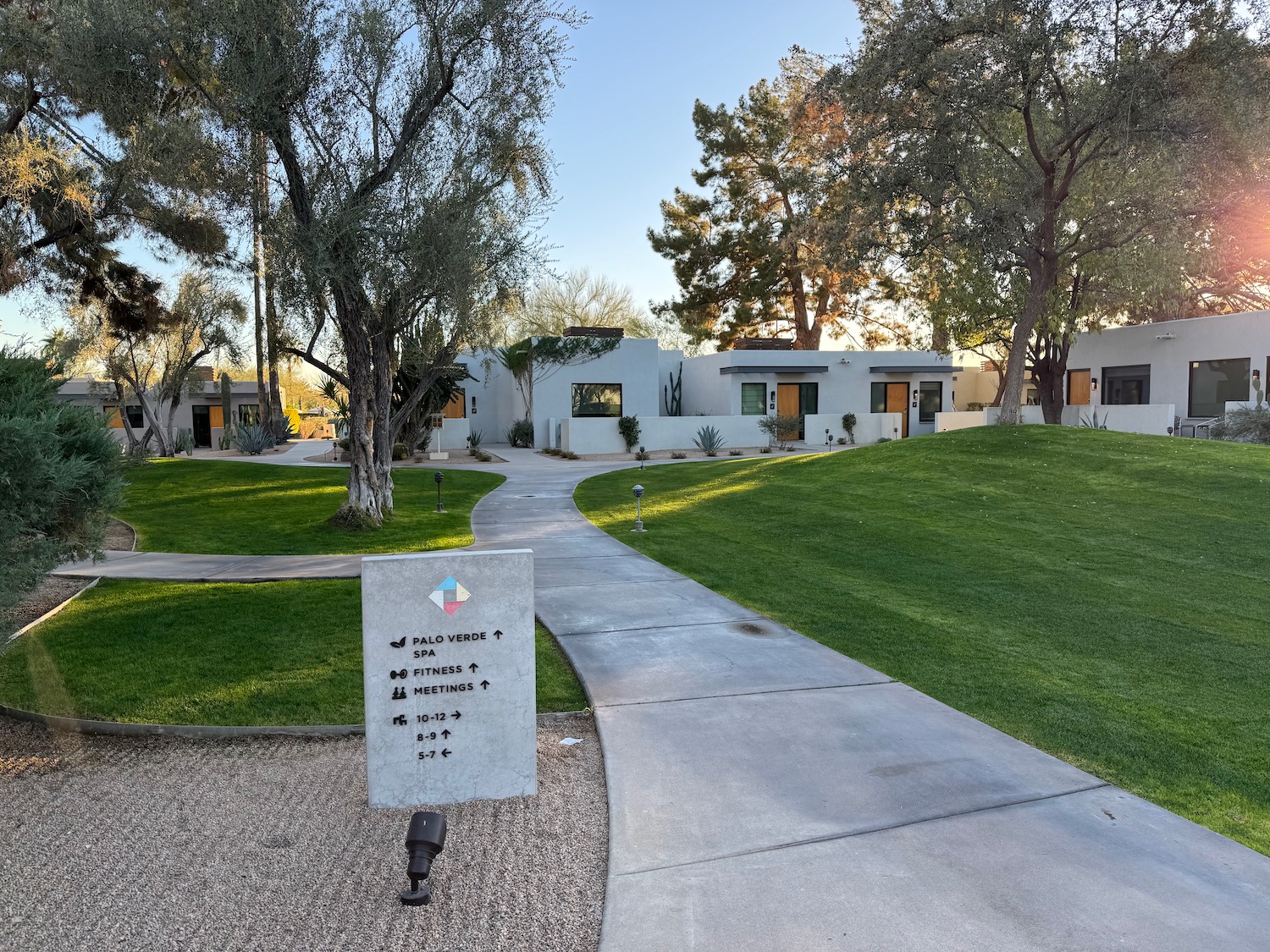 a concrete walkway with a sign in front of a house