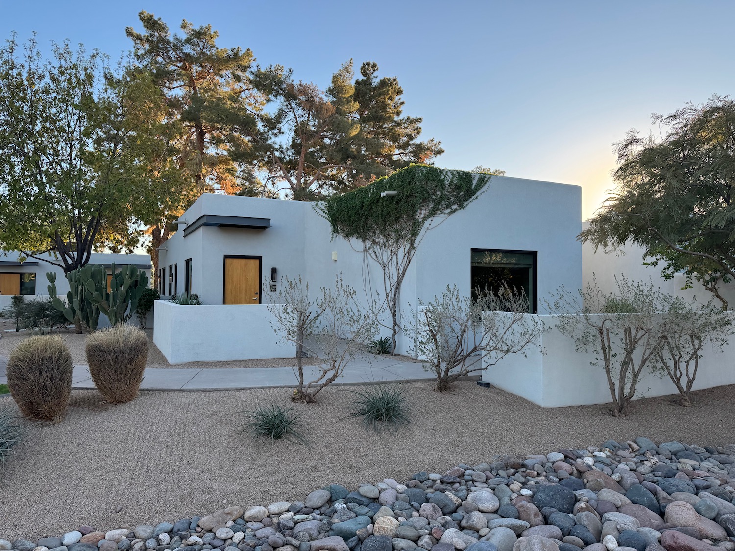 a white house with a gravel driveway and trees