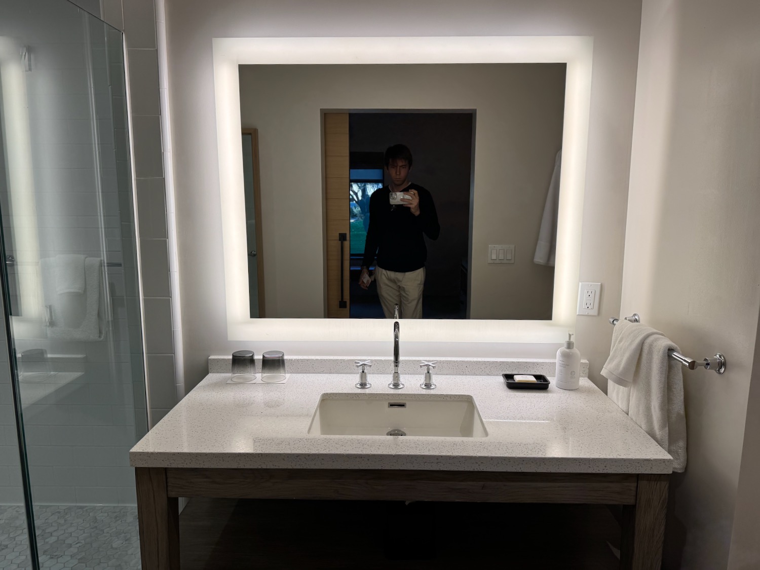 a mirror with a person taking a selfie in a bathroom