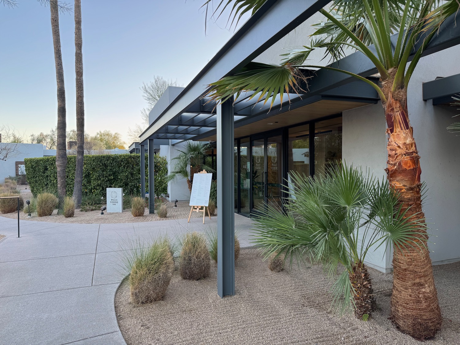 a building with palm trees and a sign