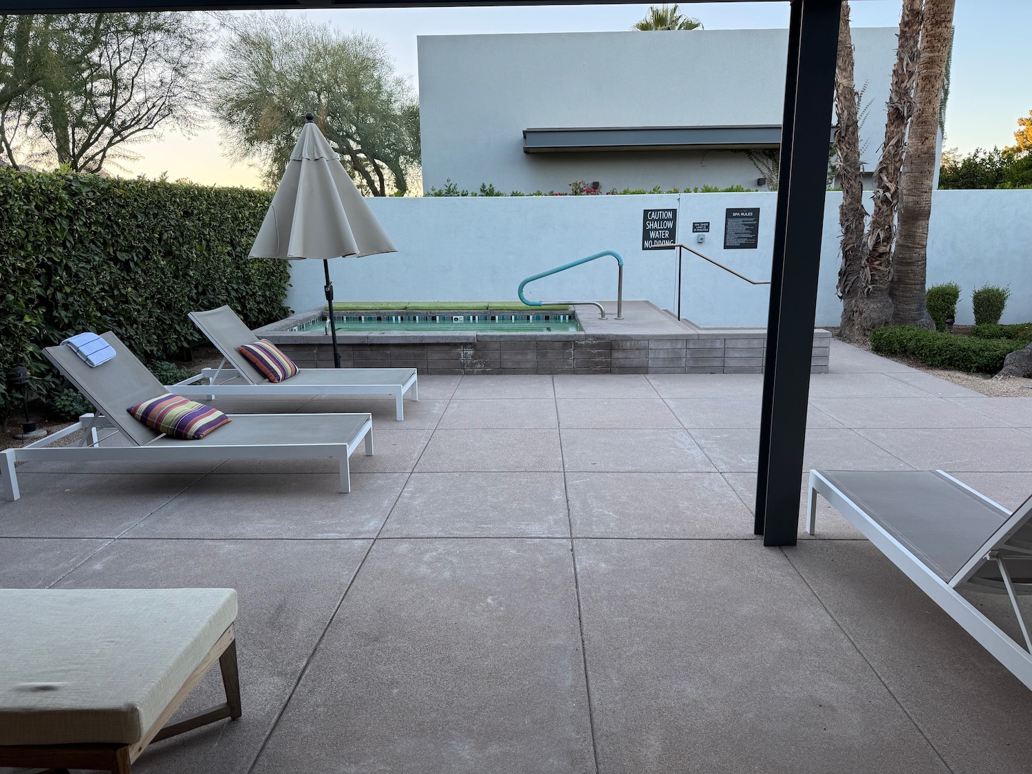 a patio with lounge chairs and a pool