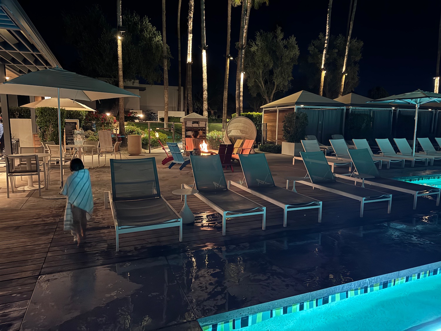 a person walking near chairs and a fire