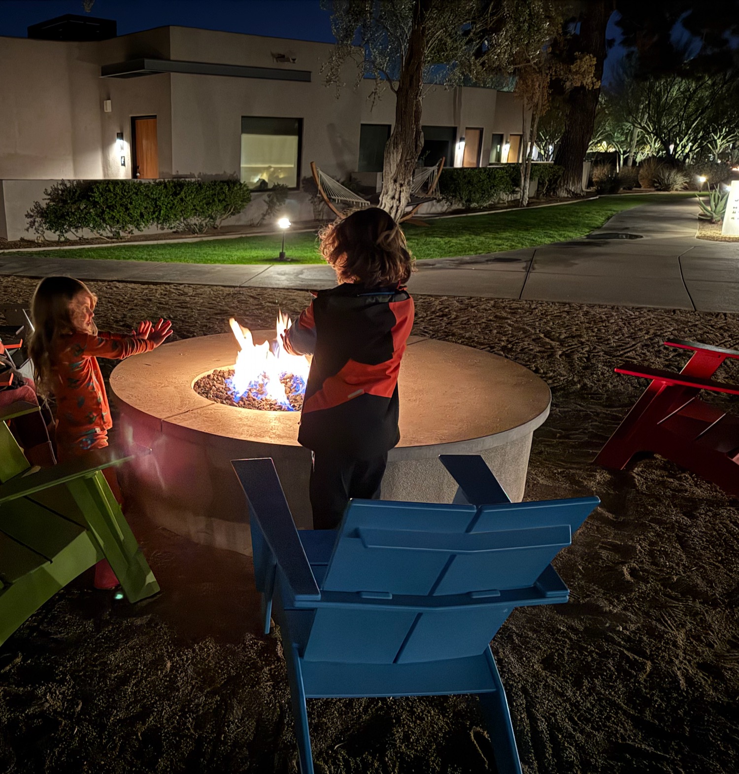 a group of children standing around a fire pit